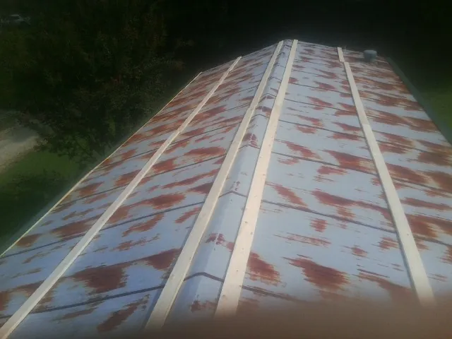 Rusted metal roof panels with new wood purlins before replacement — Storm Damage Roof Repair in Guthrie by Roofing Brothers