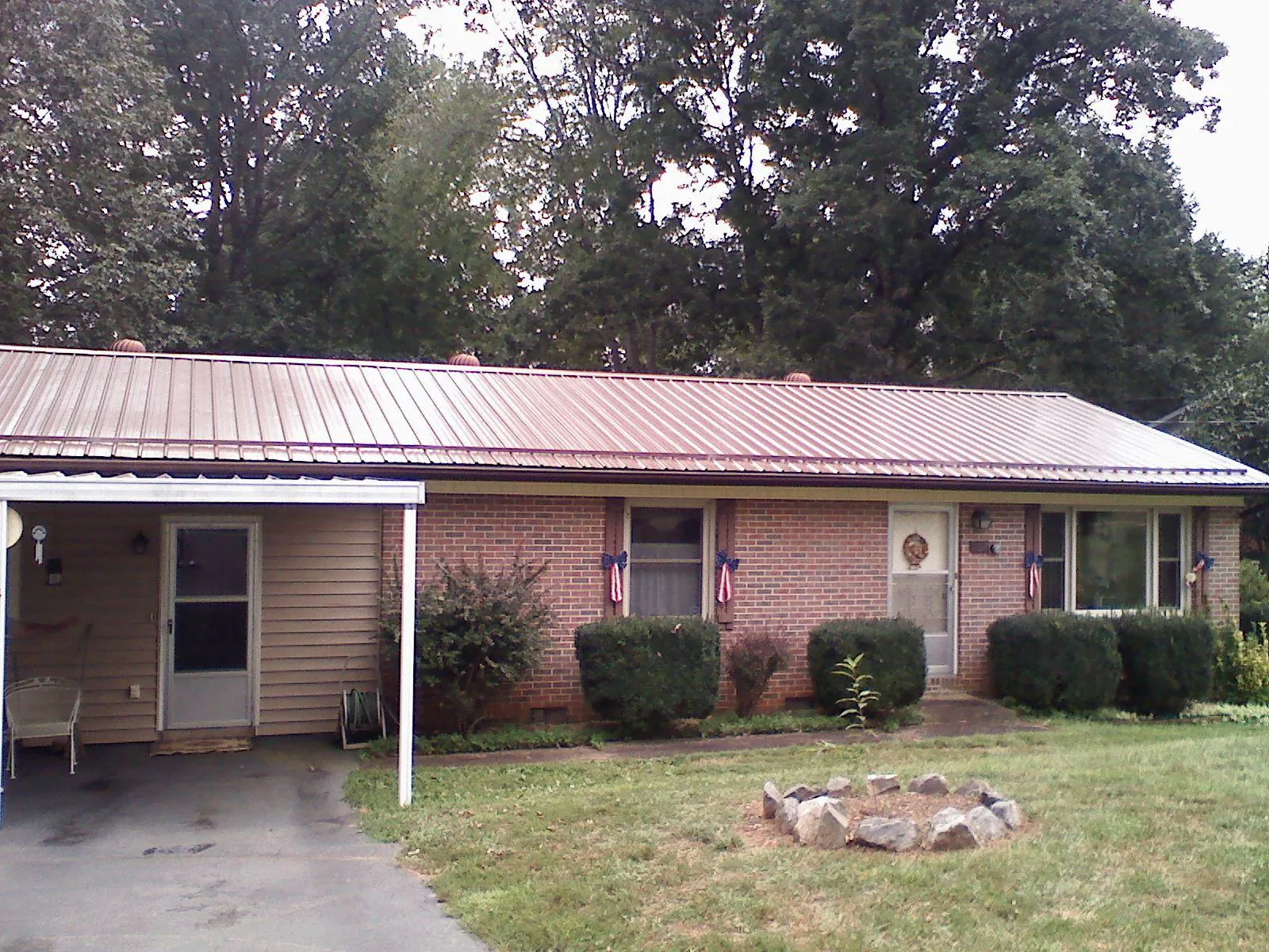 Bronze metal roof and carport on a brick ranch home — Roof Repair work by our crew in Guthrie