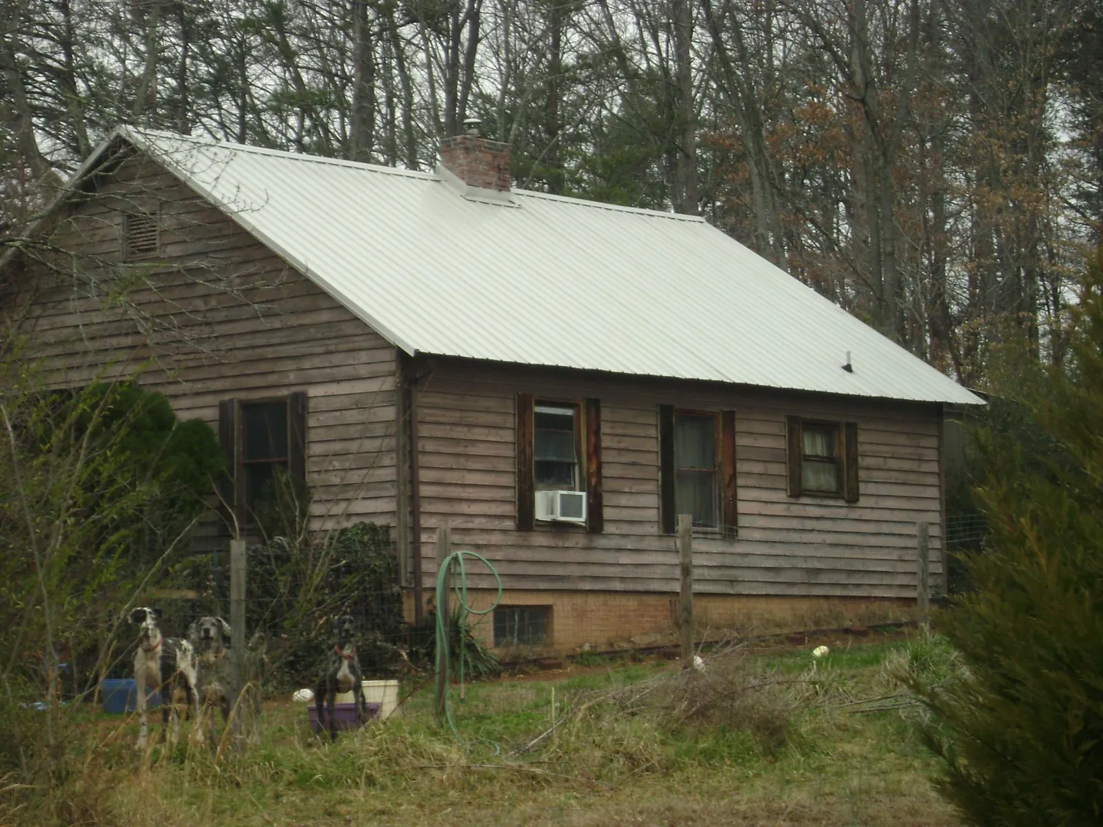 White metal roof on an old wood sided farmhouse, from a Asphalt Shingle Roof Repair job in Guthrie